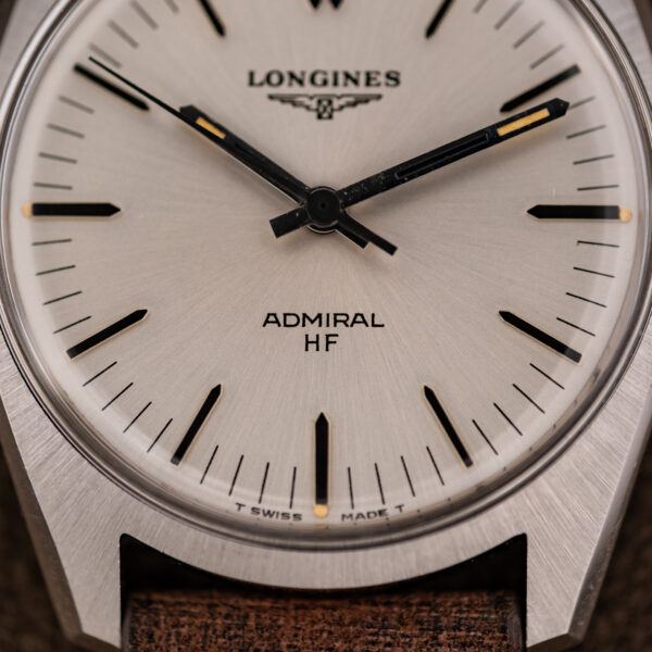 Lower dial of the Longines Admiral HF showing HF lettering, T SWISS MADE T and yellow-toned quarter plot at six