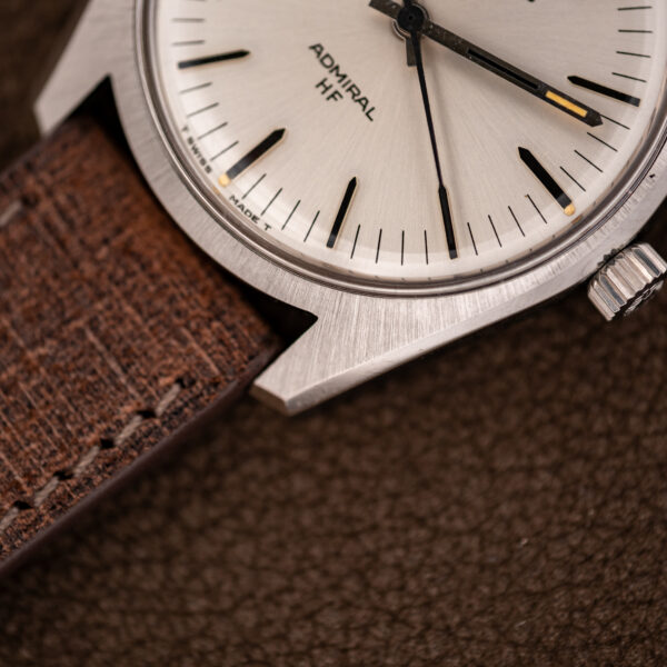 Close view of a lug and the dial edge on the Longines Admiral HF, brushed shoulder flowing into the strap