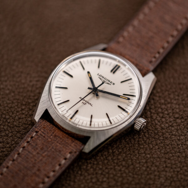 Low crown-side angle of the Longines Admiral HF showing the white dial, center seconds hand and angular case shoulders