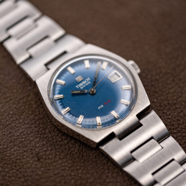 Low angle on the Tissot PR 516 cushion case with blue dial, date window and steel bracelet