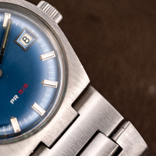 Close-up of the Tissot lower case and bracelet junction beside the blue PR 516 dial