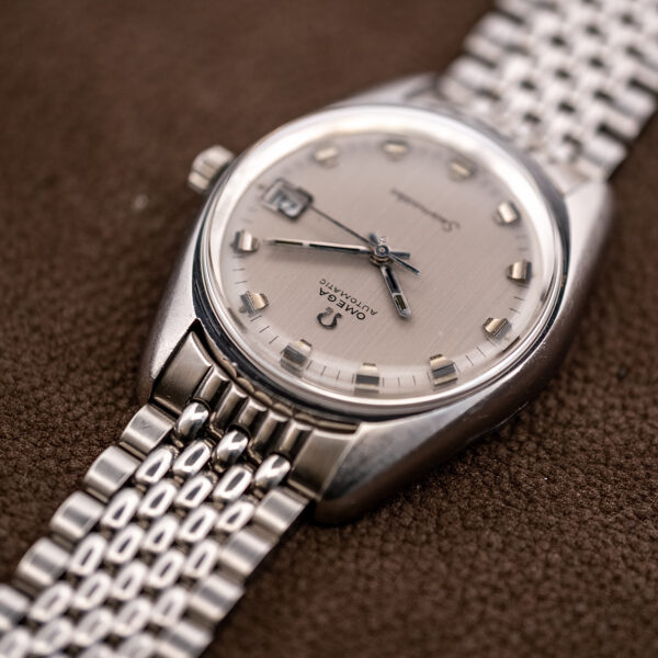 Inverted oblique view of the Omega 166.067 showing short applied markers, stick hands and bracelet end link