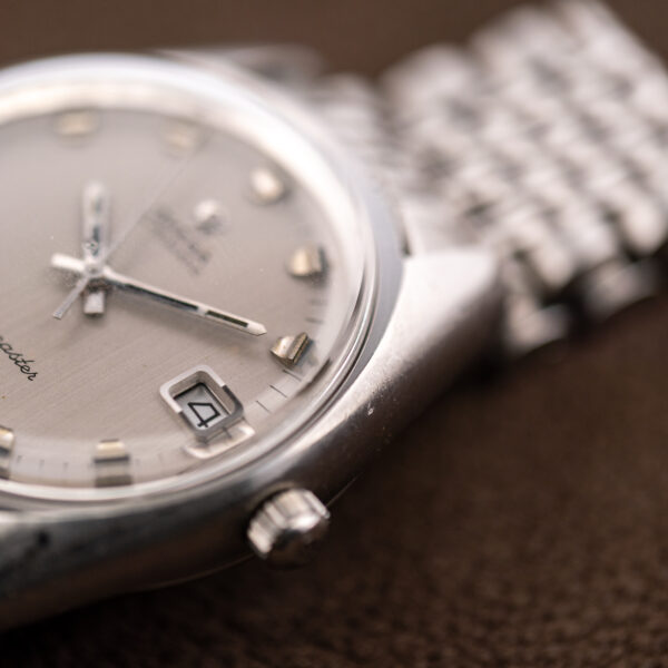 Close crown-side view of the Omega 166.067 showing the framed date window and rounded case shoulder