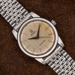 Omega Seamaster 165.009 ribbon dial seen from above on a silver multi-row beads-of-rice bracelet
