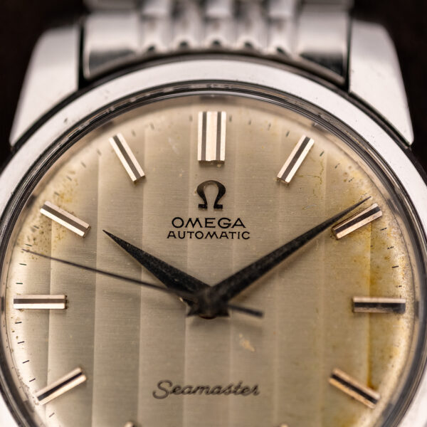 Upper dial macro of the Omega Seamaster 165.009 showing Omega lettering, vertical bands and edge toning