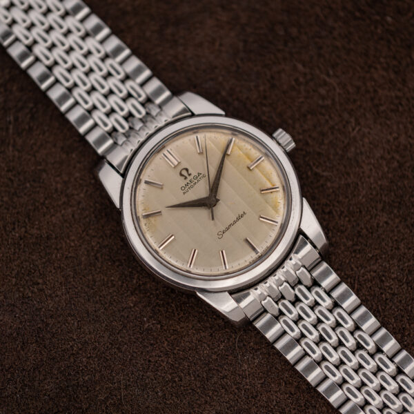 Wide front angle of the steel Omega Seamaster 165.009 with its silver multi-row bracelet