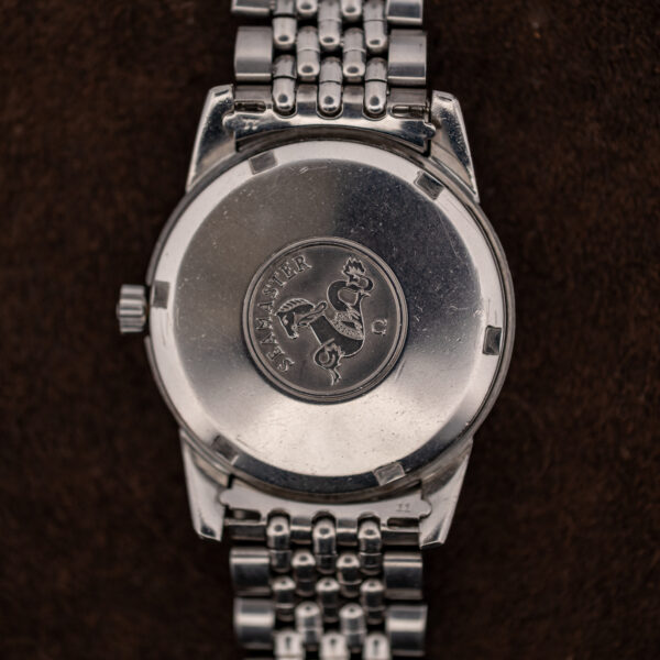 Screw-down Seamaster caseback of the Omega 165.009 with medallion and end pieces stamped 11