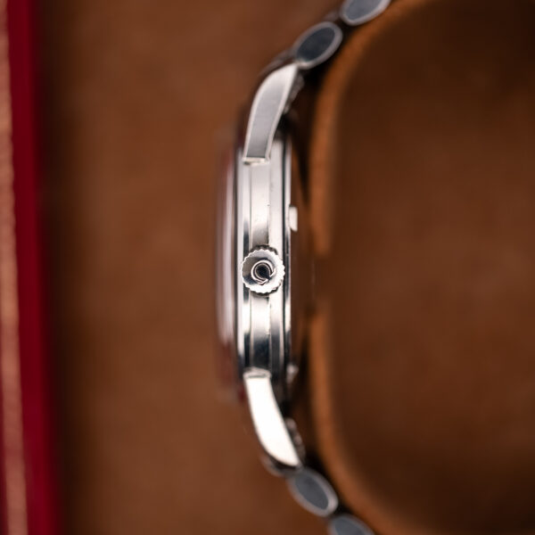 Oblique front view of the Omega Seamaster ribbon dial and bracelet resting on a red-edged support