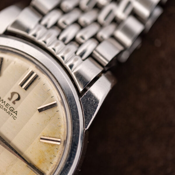 Close-up of the upper-right lug, bezel, bracelet end link and dial edge of the Omega Seamaster
