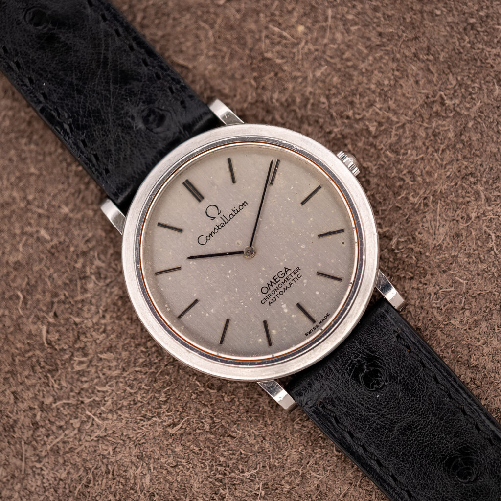 Omega Constellation 157.0001 seen diagonally, showing the flecked silver dial, baton markers and black ostrich strap