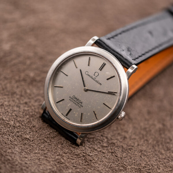 Omega Constellation 157.0001 standing upright on a display stand, two-hand silver dial and black ostrich strap