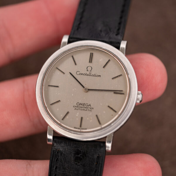 Hand-held angled view of the Omega Constellation 157.0001 ultra-thin chronometer with brushed silver dial