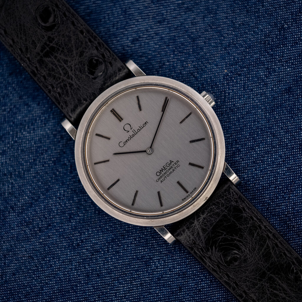 Omega Constellation 157.0001 viewed diagonally, showing the evenly brushed silver dial, two hands and black ostrich strap