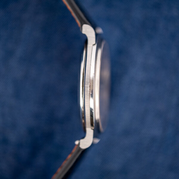 Profile of the Omega 157.0001 opposite the crown, showing downturned lugs and the raised crystal edge