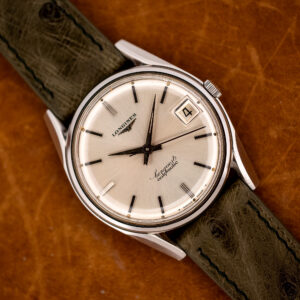 Longines Conquest 7171-2 seen diagonally, silver sunburst dial with applied batons, date at three and olive strap