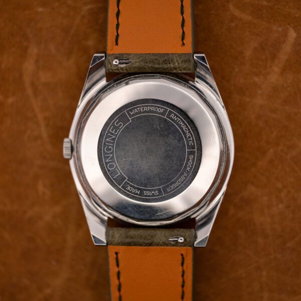 Outer caseback of the Longines Conquest 7171-2 with its circular engraved legend and olive strap undersides