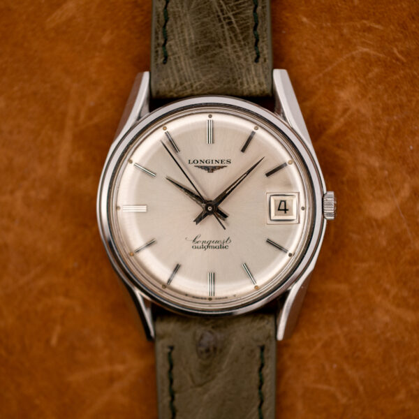Straight-on view of the Longines Conquest 7171-2 dial with applied batons, date at three and signed script