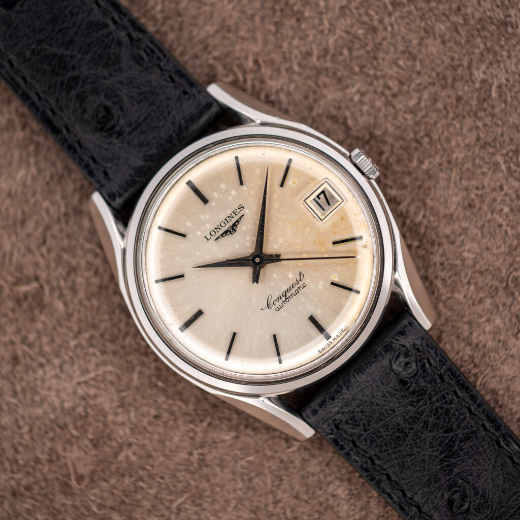 Longines Conquest 7171-5 seen diagonally, spotted silver sunburst dial, date at three and black ostrich strap