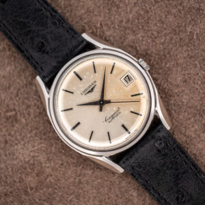 Longines Conquest 7171-5 seen diagonally, spotted silver sunburst dial, date at three and black ostrich strap