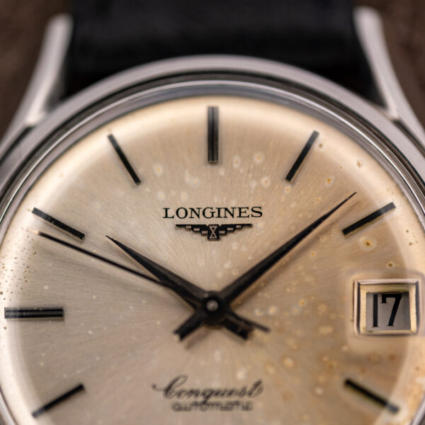 Upper dial macro of the Longines Conquest 7171-5 with winged-hourglass applique, slim batons and date window
