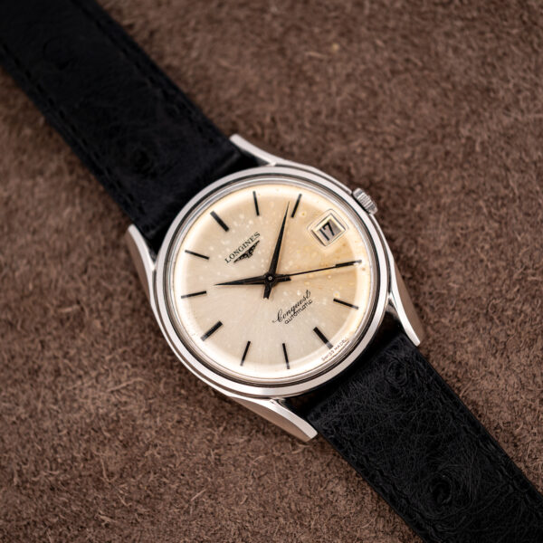 Reverse diagonal angle on the Longines Conquest 7171-5, showing the aged silver dial and magnified date