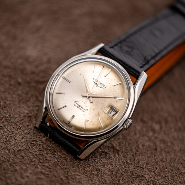 Three-quarter view of the Longines Conquest 7171-5 showing dial spotting and warm tone at the edge
