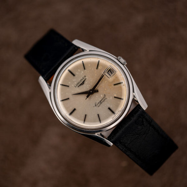 Raised reverse diagonal view of the Longines Conquest 7171-5 silver dial, batons and date at three