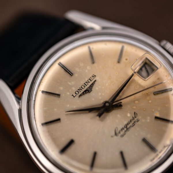 Oblique macro of the Longines Conquest 7171-5 dial showing sunburst brushing, spots and applied markers