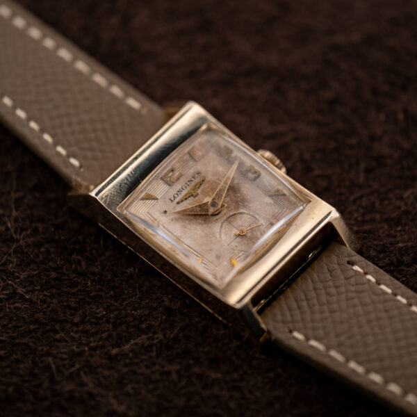 Longines 9LT tank at an angle, showing the broad lug shoulders and the numeral-and-triangle dial