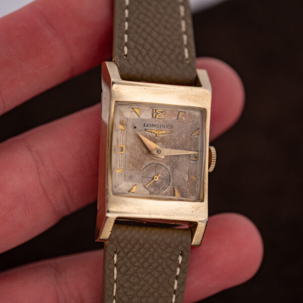 Longines 2172-10 held in hand, showing the rectangular numeral dial, small seconds and shaped lugs