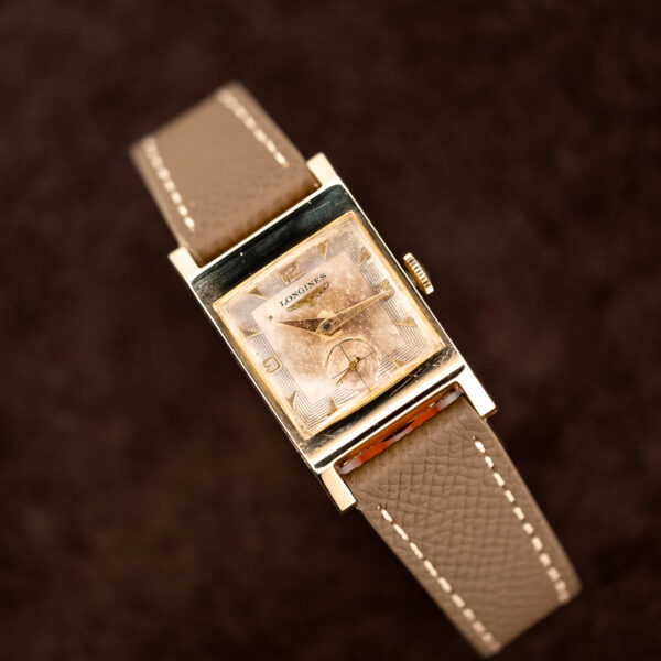 Longines 2172-10 angled on a stand with applied numerals, crosshair seconds and taupe leather strap