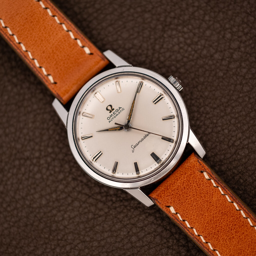 Omega Seamaster 14704 white dial seen from above, steel case on a tan strap with light stitching