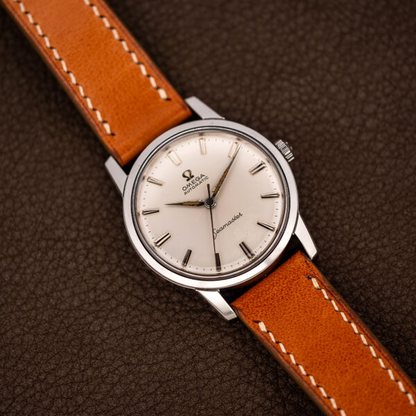 Wide front angle of the steel Omega Seamaster automatic with white dial and tan leather strap