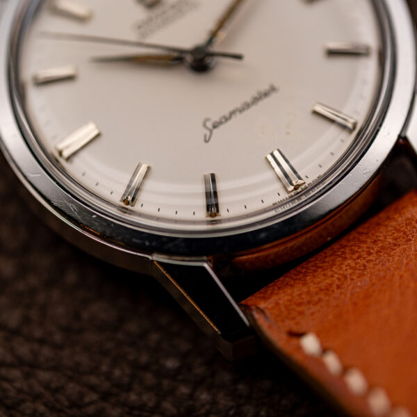 Close-up of the lower Seamaster dial, faceted hour markers, steel bezel and lug of the 14704