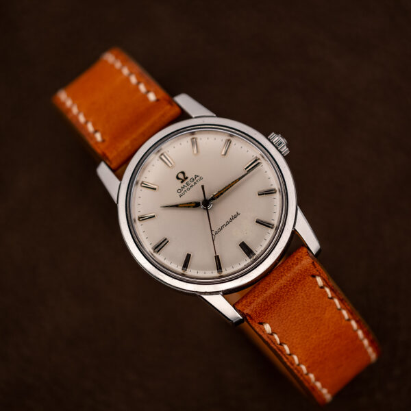 Omega Seamaster 14704 from the opposite angle, showing the smooth steel bezel and tan strap