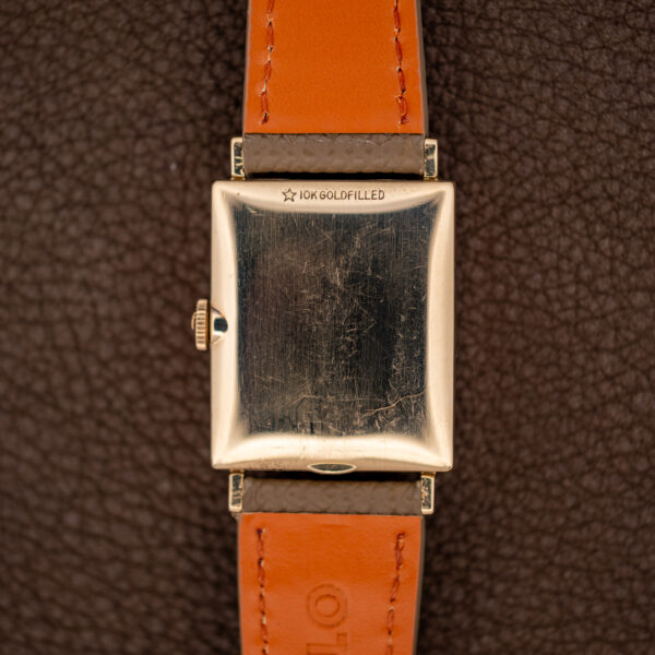 Longines 1137 gold-filled caseback with a five-point star and stamped lettering between the taupe strap ends