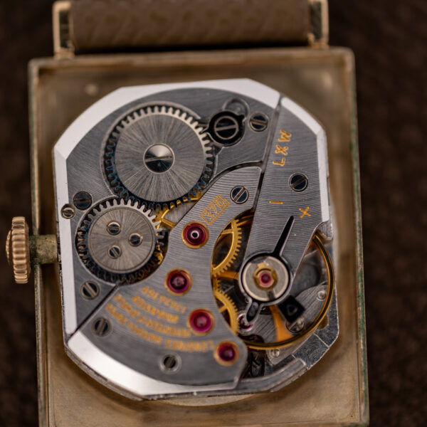 Close-up of the Longines caliber 370 hand-wound movement showing winding wheels, balance and caliber stamp