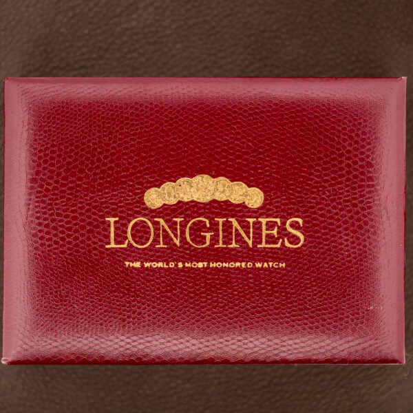 Closed red Longines presentation box with gold lettering and a medal motif on the lid