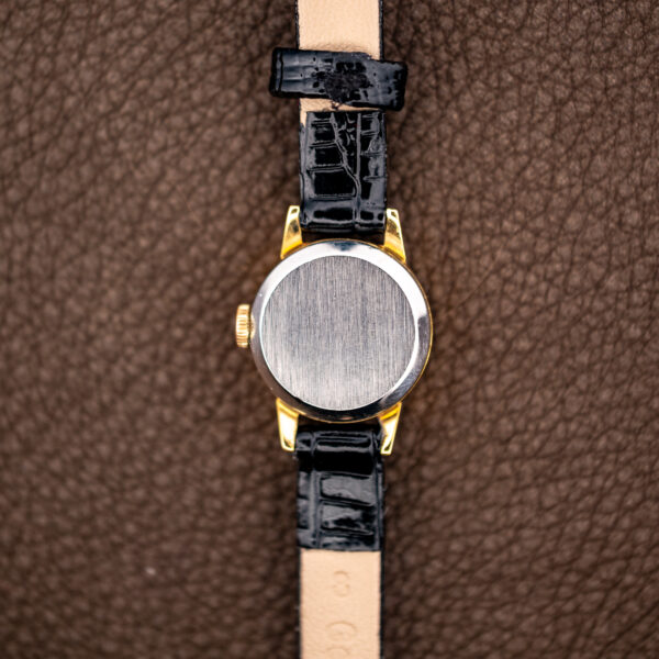 Plain brushed caseback of the Omega 511.166 with polished border and pale strap lining