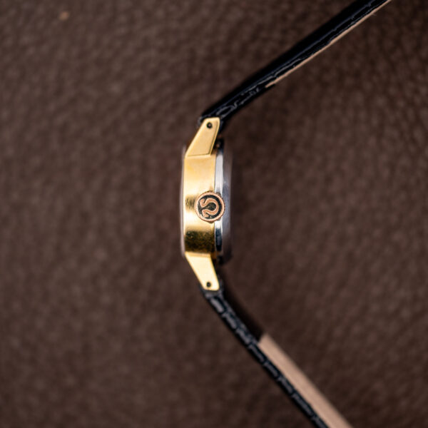 Crown-side profile of the small Omega case showing the Omega-symbol crown and drilled lug holes