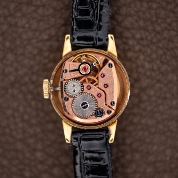 Omega caliber 484 hand-wound movement seen straight on in the open case, winding wheels exposed